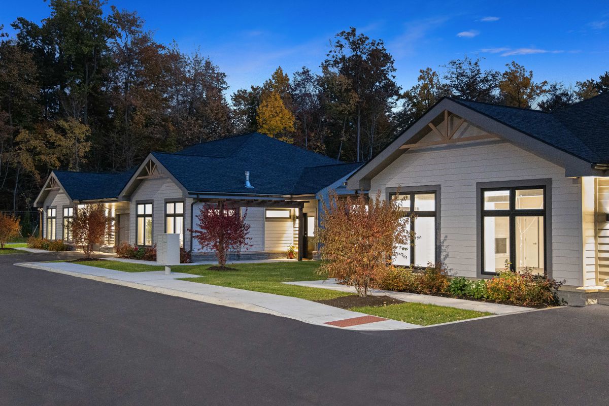 A modern suburban house in the evening with landscaped surroundings.