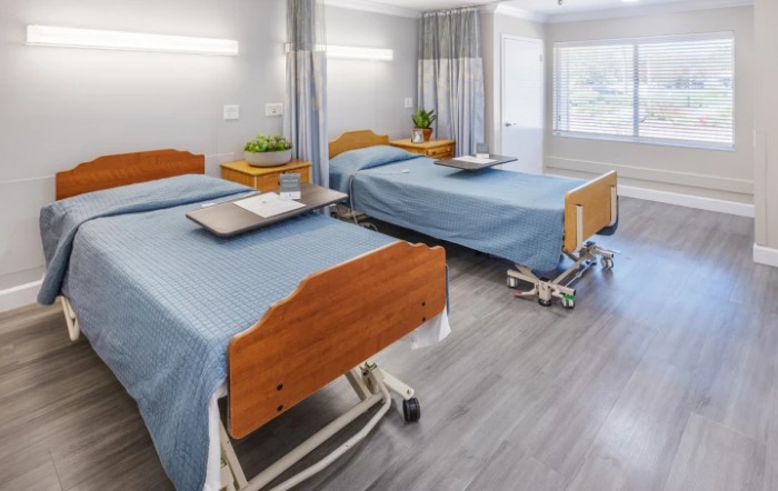 A clean and modern hospital room with two beds and medical equipment.