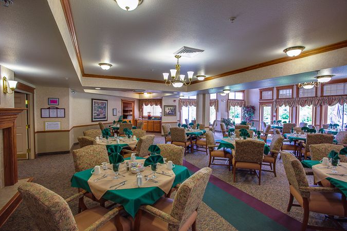A spacious dining area with neatly arranged tables and chairs, featuring elegant interior decor and lighting.