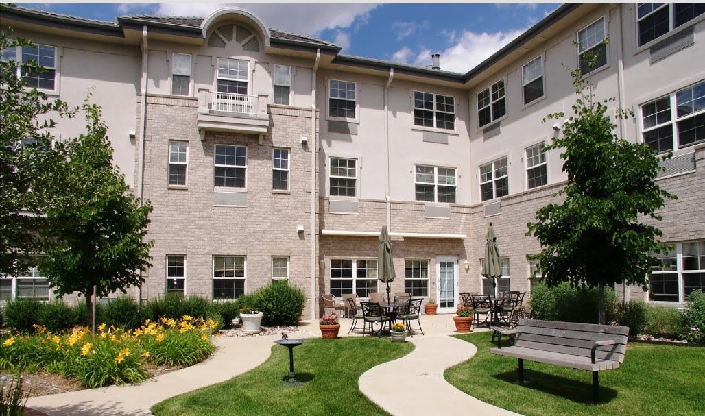 A residential building with an inviting courtyard featuring a garden and outdoor seating area.