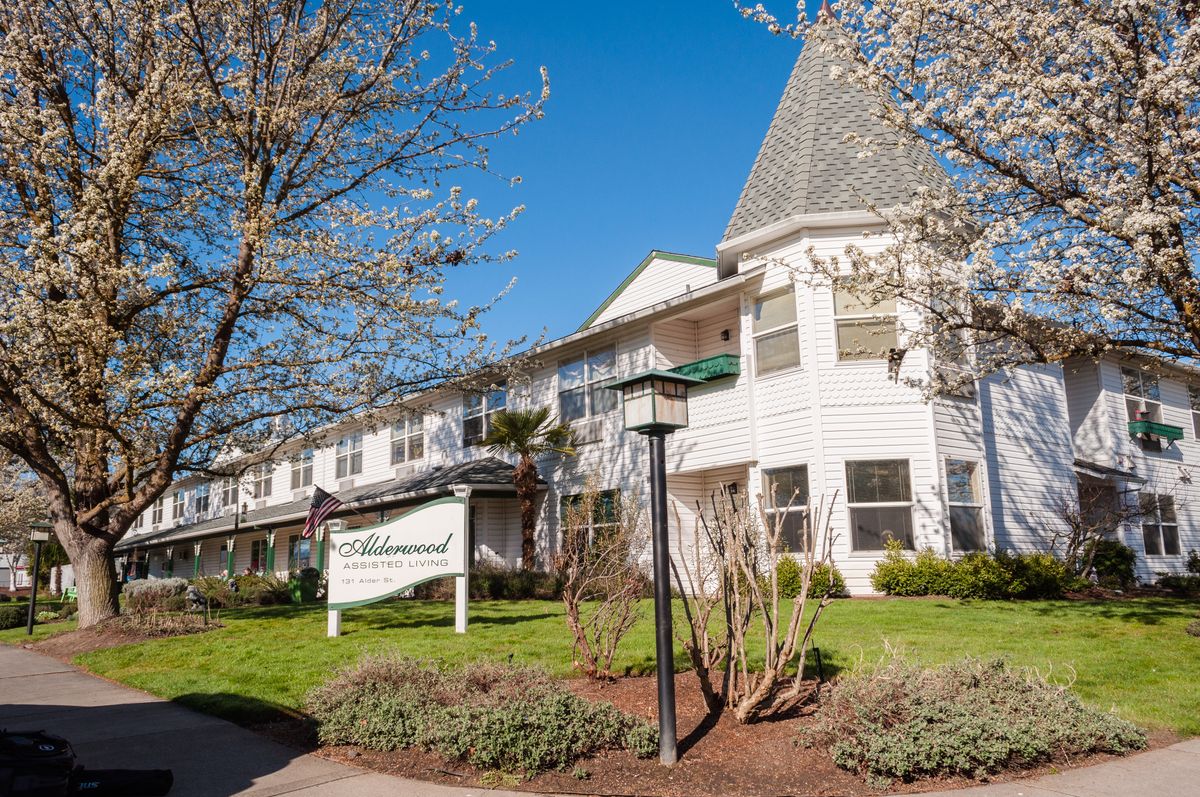 A charming residential building surrounded by trees on a sunny day.