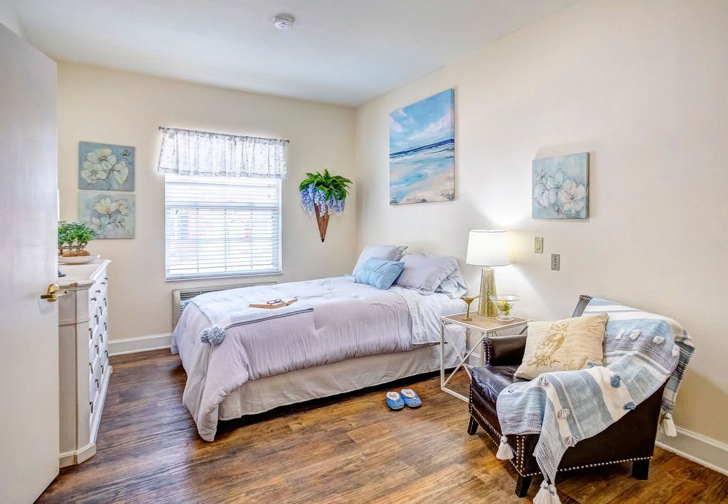 A cozy bedroom with artwork, a comfortable bed, and soft lighting.