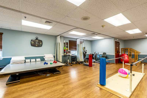 A spacious therapy room equipped with various fitness tools and a welcoming atmosphere.