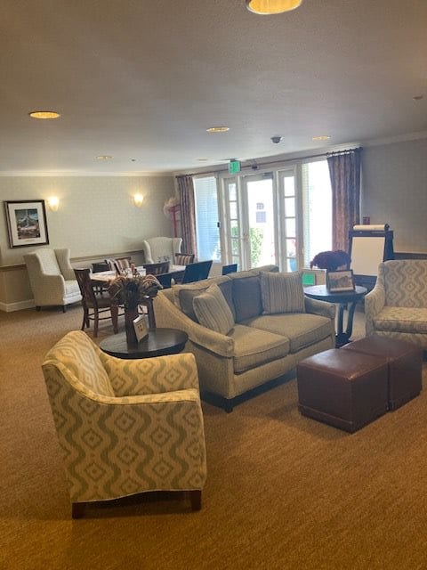 A cozy living room with comfortable seating and natural light from large windows.