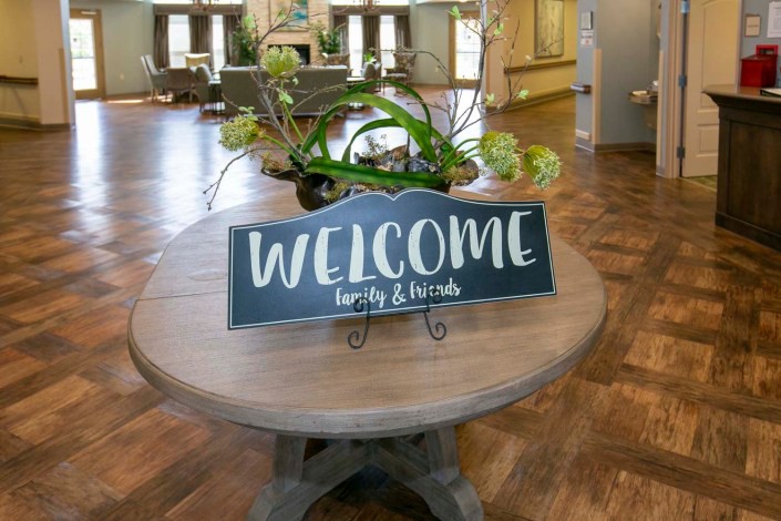 A welcoming sign on a table in a cozy lobby area.