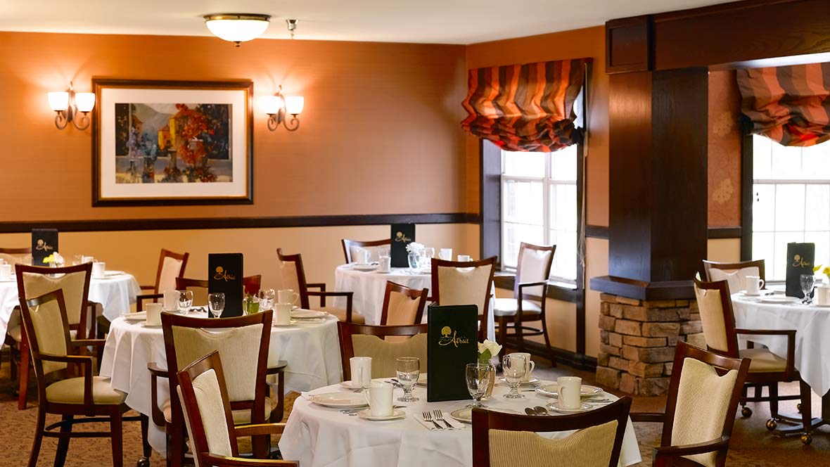 An elegant restaurant dining room with neatly arranged tables and warm decor.