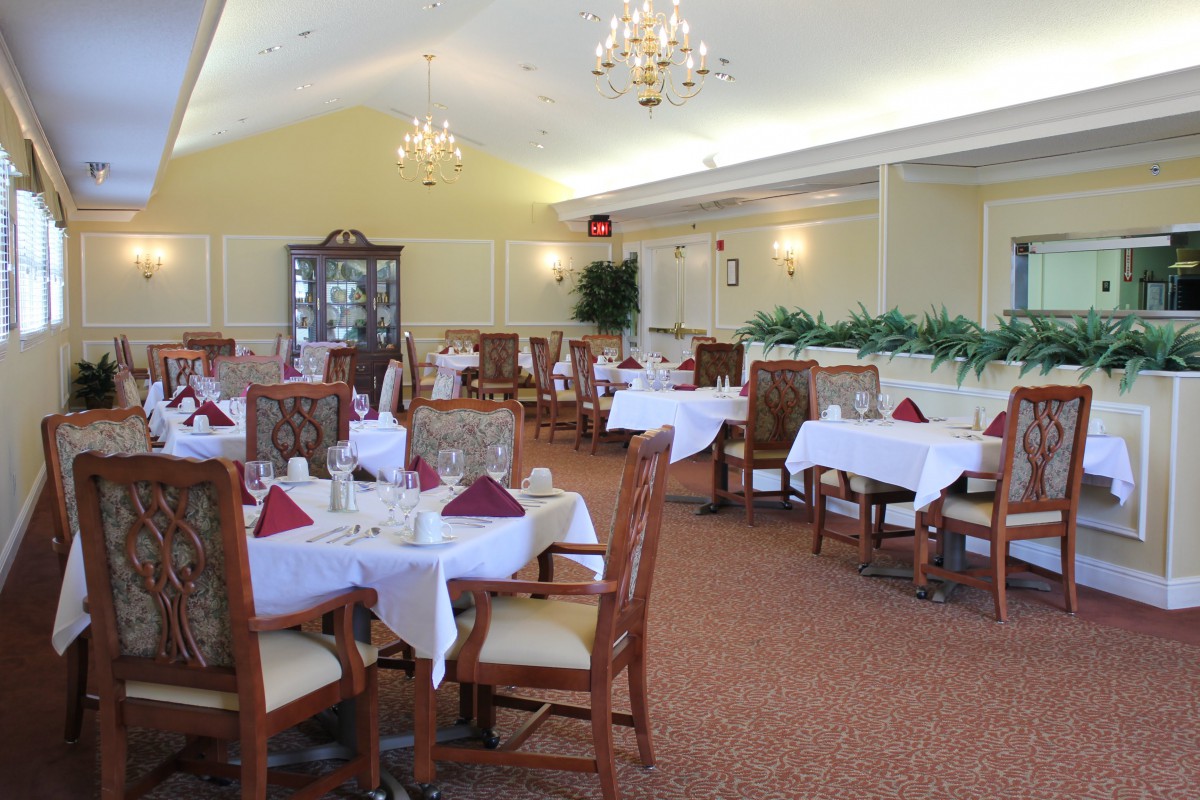An elegant dining room with neatly arranged tables and chandeliers.