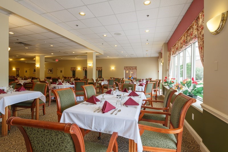An elegantly set dining room with neatly arranged tables and chairs.