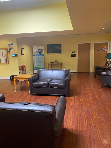 A cozy lounge area featuring black sofas and a warm, inviting atmosphere.