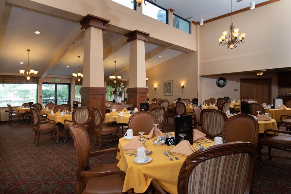 An elegant dining area with neatly arranged tables and chairs, featuring warm lighting and classic decor.