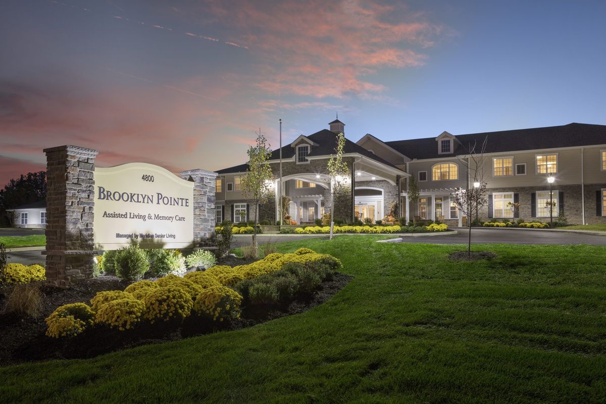 Illuminated building with landscaped grounds at dusk.