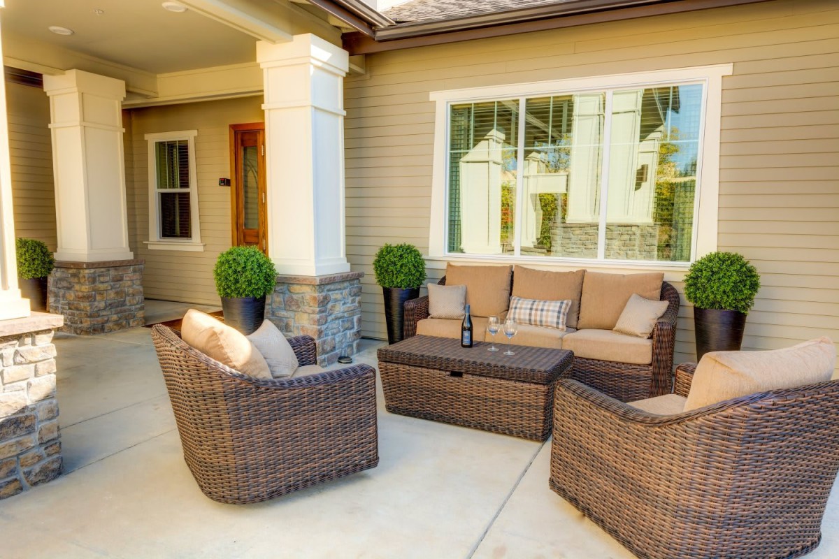 A cozy patio setup featuring wicker furniture with comfortable cushions, perfect for outdoor relaxation.