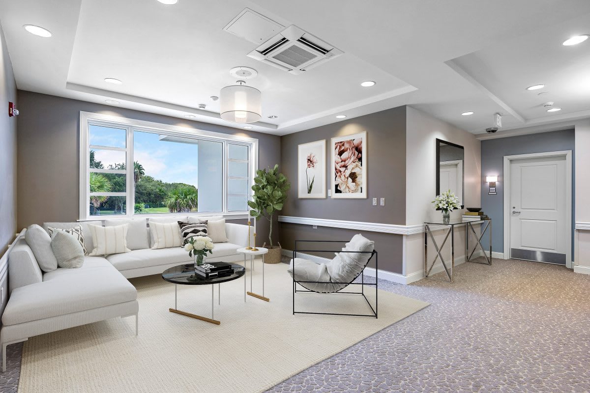 A modern living room with neutral tones, featuring a large window and contemporary furniture.