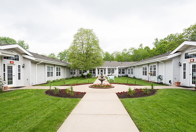 A serene courtyard with landscaped gardens and a central pathway leading to surrounding buildings.