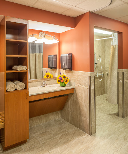 A well-designed bathroom featuring a sink, mirror, and an inviting arrangement of towels and flowers.