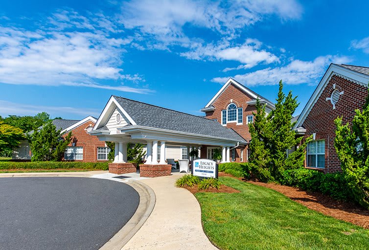A beautiful residential building with well-maintained landscaping and a clear blue sky.
