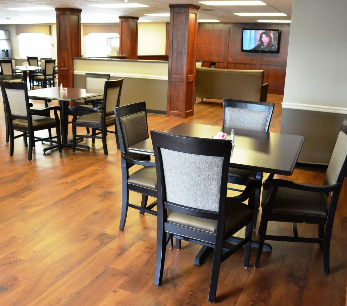 A clean and modern dining area with neatly arranged tables and chairs.