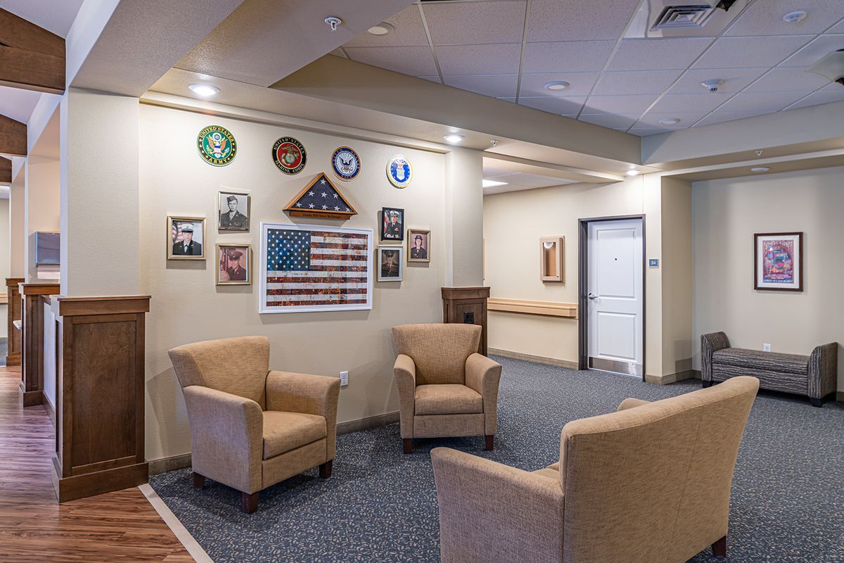 A cozy lobby area decorated with armchairs and military-themed wall decor.