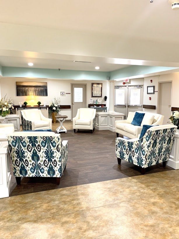 A modern lobby with comfortable seating arrangements, including armchairs and sofas, set in a well-lit interior.