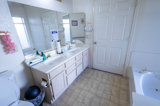 A spacious and clean bathroom featuring a dual-sink vanity and large mirror.