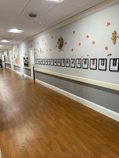 A hallway featuring a series of framed photographs along the wall, adorned with colorful decorations.