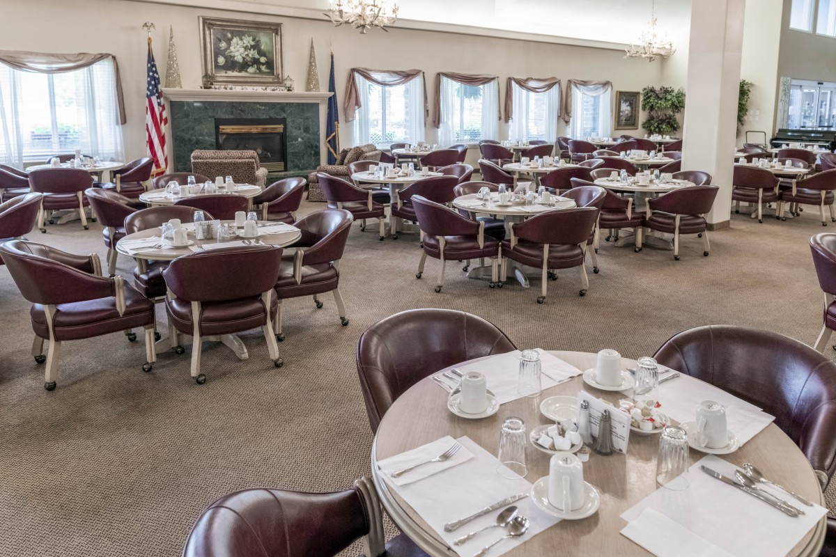 A formal dining room with multiple set tables ready for service.