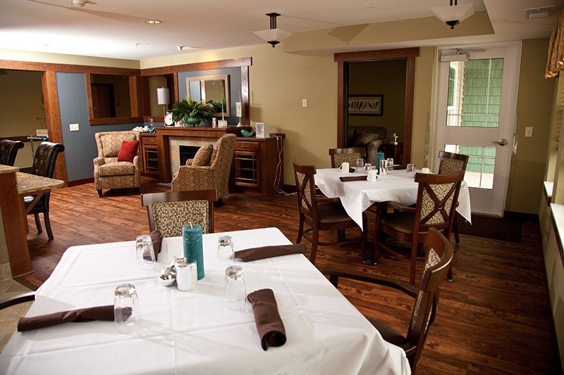 A cozy and elegantly furnished dining area with neatly arranged tables and chairs.