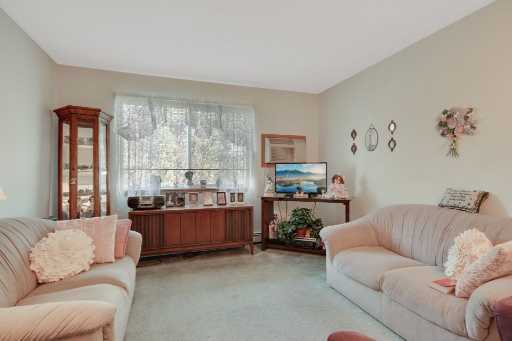 A cozy living room featuring a sofa, television, and various decorative elements.