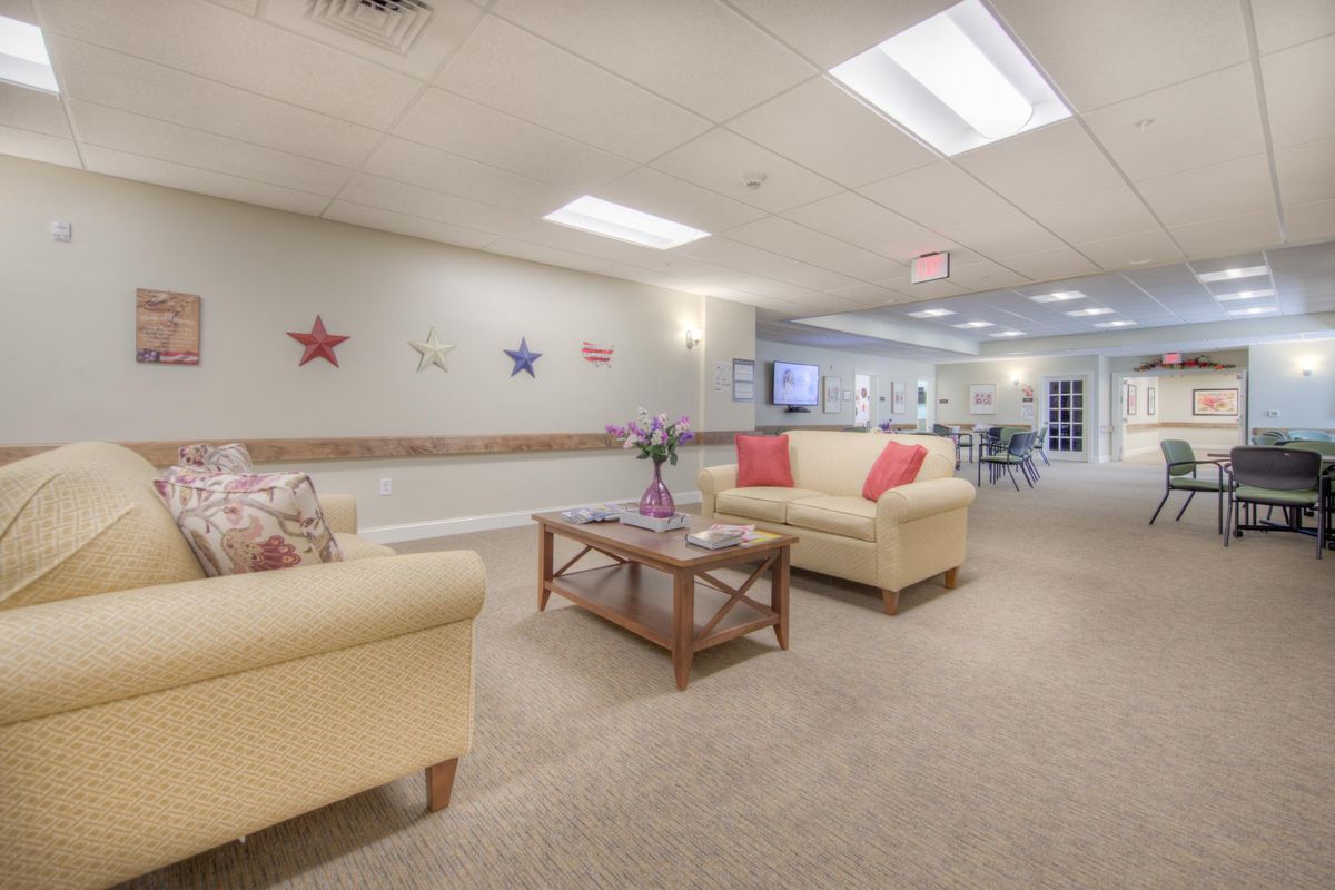A cozy living room with comfortable sofas, a coffee table, and decorative wall accents.