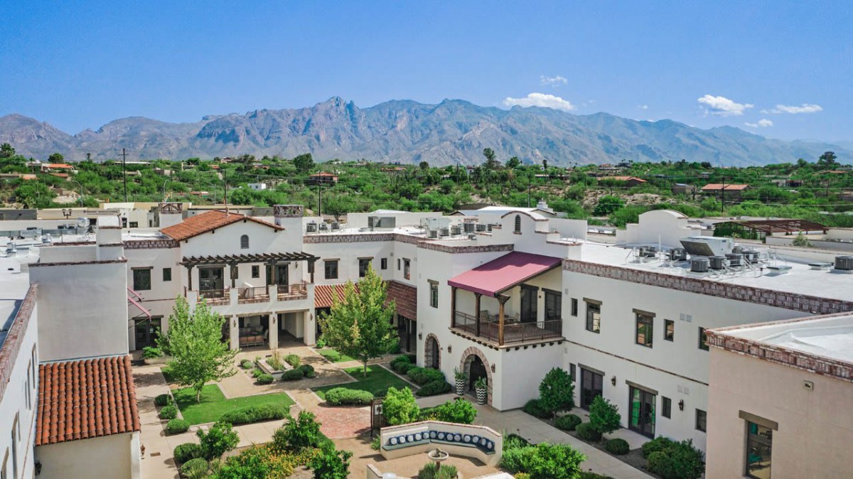 A picturesque view of a resort with a mountainous backdrop and lush greenery.