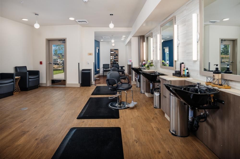 A modern salon with styling stations and washing sinks.