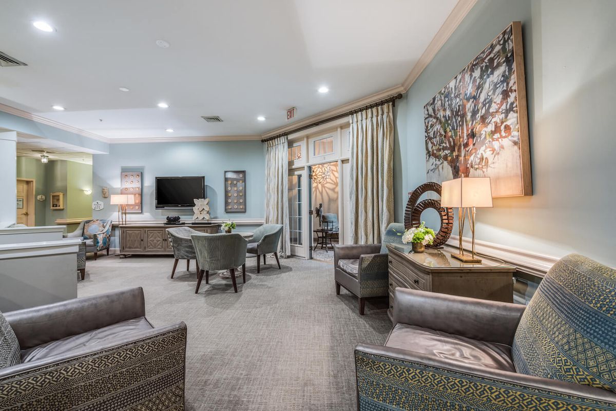 A modern living room featuring stylish furniture, a dining area, and a television.