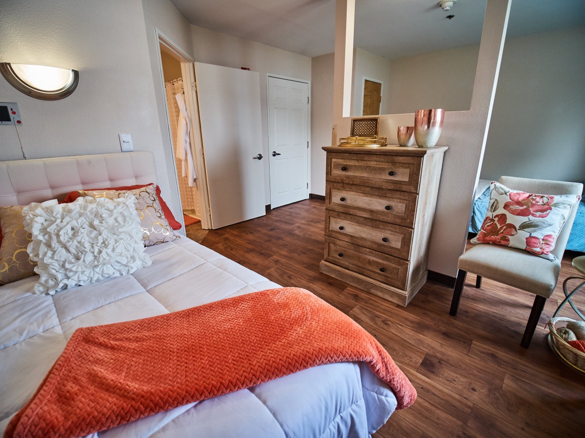 A cozy bedroom with warm decor and wooden flooring.