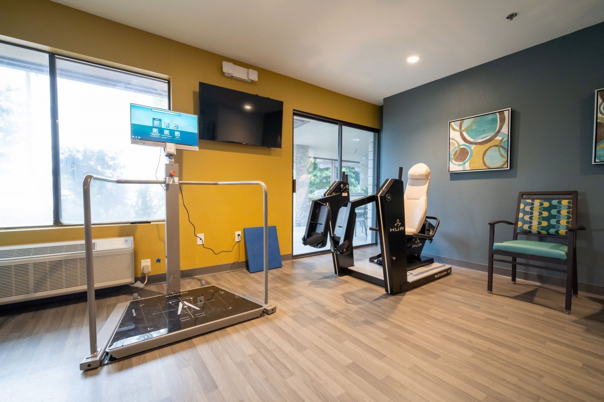 A modern gym facility with exercise equipment and a treadmill.