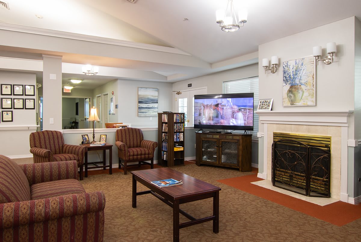A cozy living room with a television, fireplace, and comfortable seating.