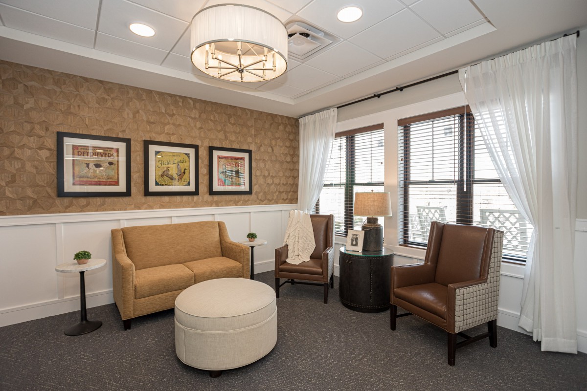 A cozy living room with modern furniture and stylish decor, featuring a brick accent wall.