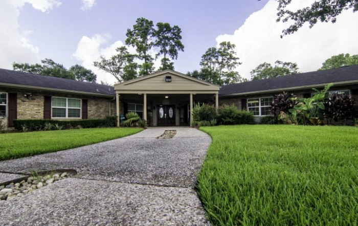 A suburban home with a wide driveway and neatly trimmed front yard.