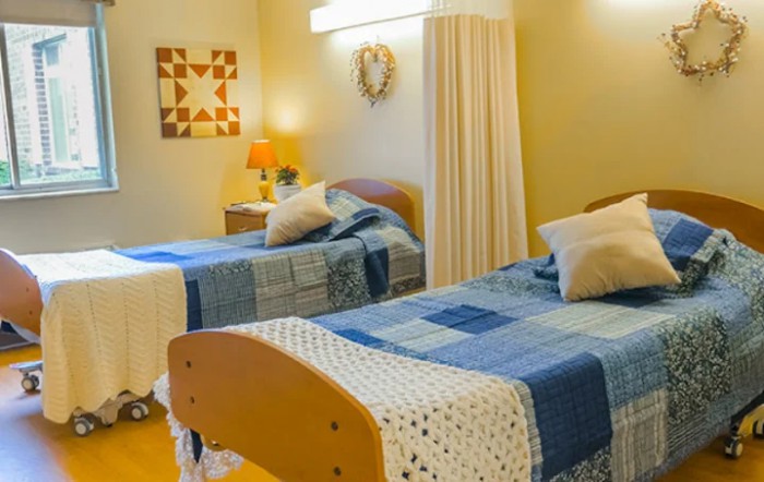 A cozy bedroom with twin beds featuring blue patchwork quilts and decorative pillows.