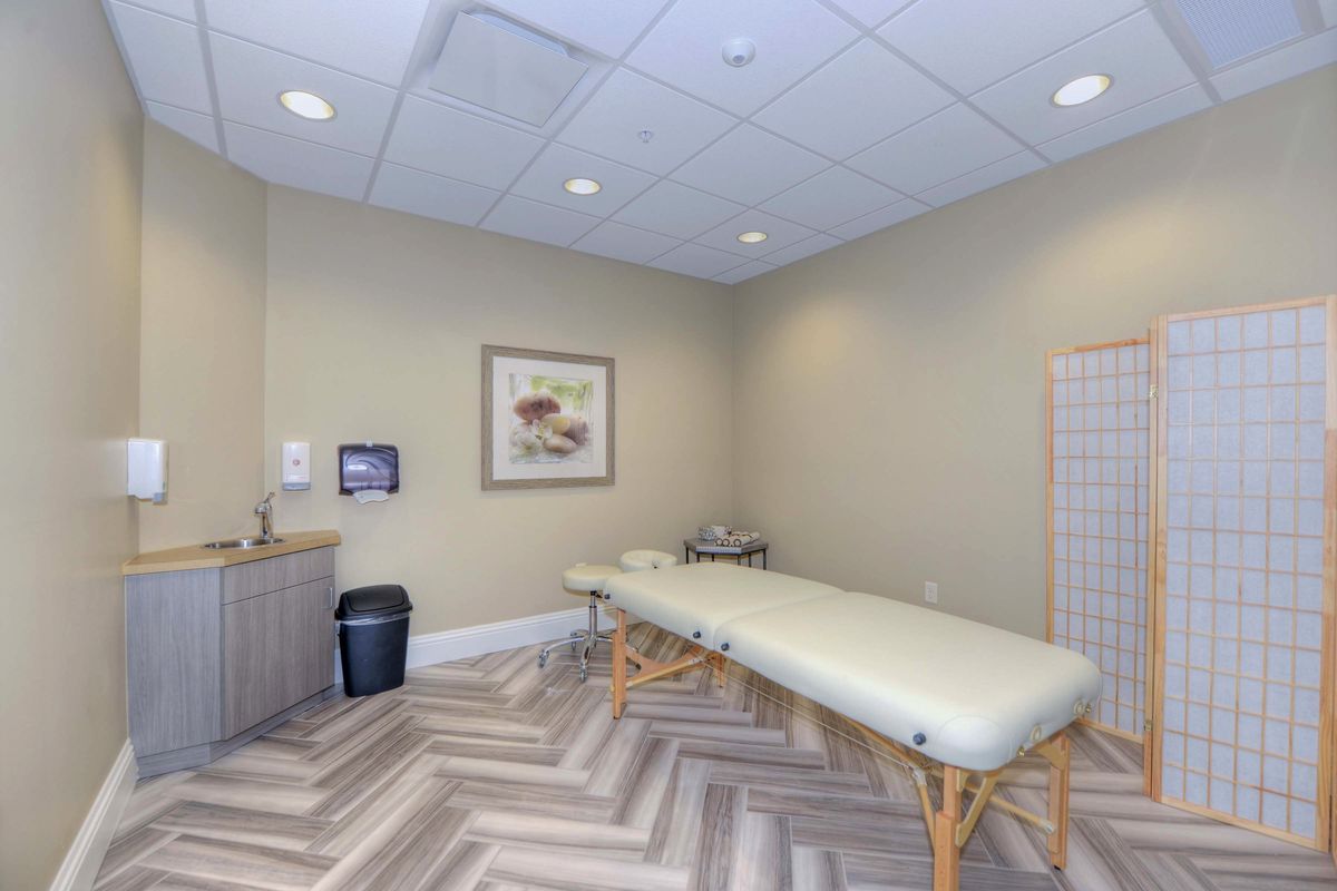 A serene massage room equipped with a treatment table, perfect for relaxation and therapy sessions.