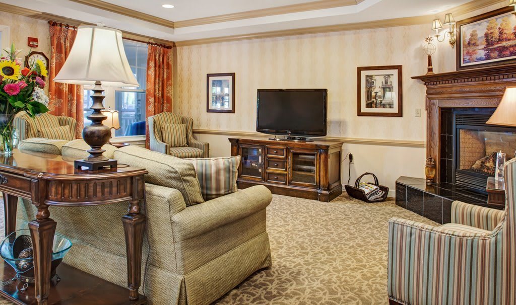 A cozy living room featuring comfortable armchairs, a television, and a stylish decor.