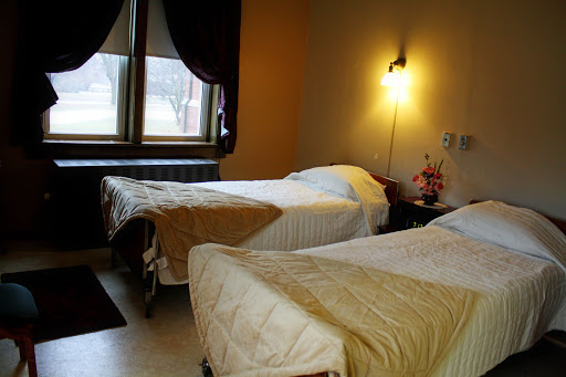 A cozy hotel room featuring two twin beds, warm lighting, and soft decor.
