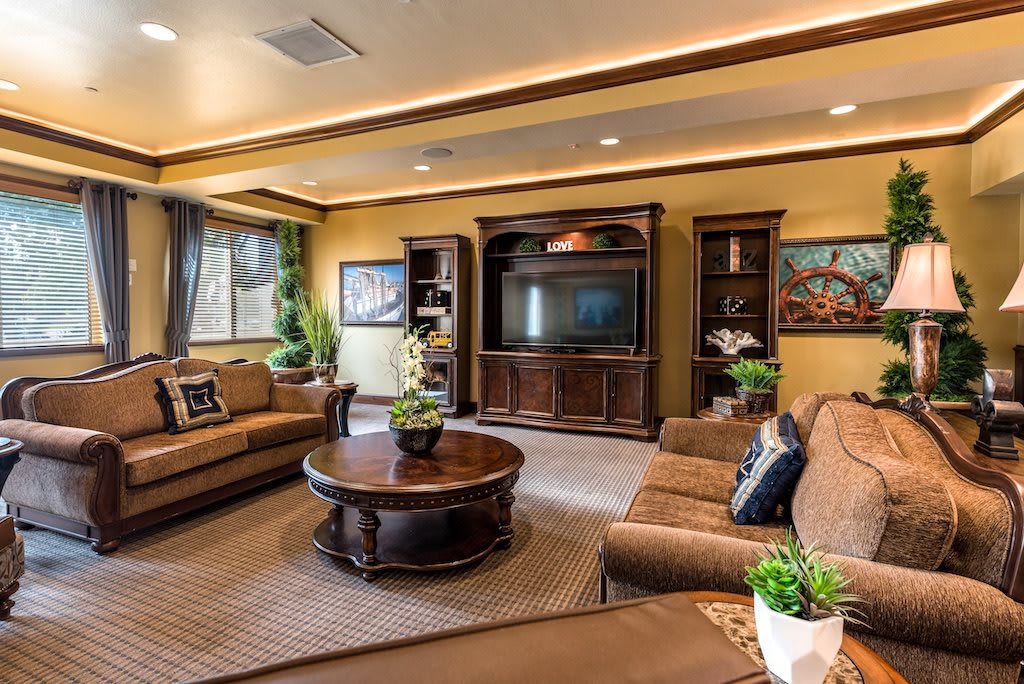 A cozy living room with warm lighting, featuring comfortable seating and a large entertainment center.