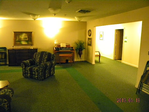 A cozy living room space featuring a patterned sofa, an organ, and soft lighting.