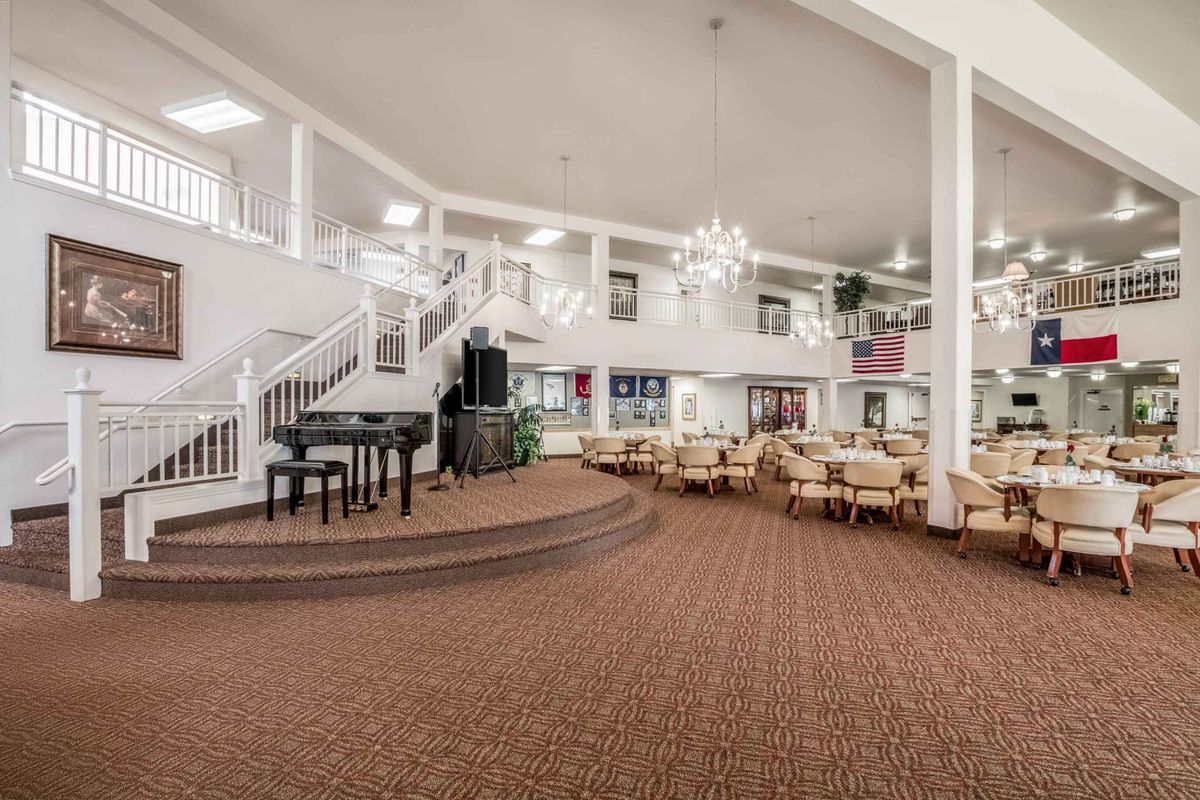 A spacious lobby with elegant chandeliers, a grand piano, and comfortable seating areas.