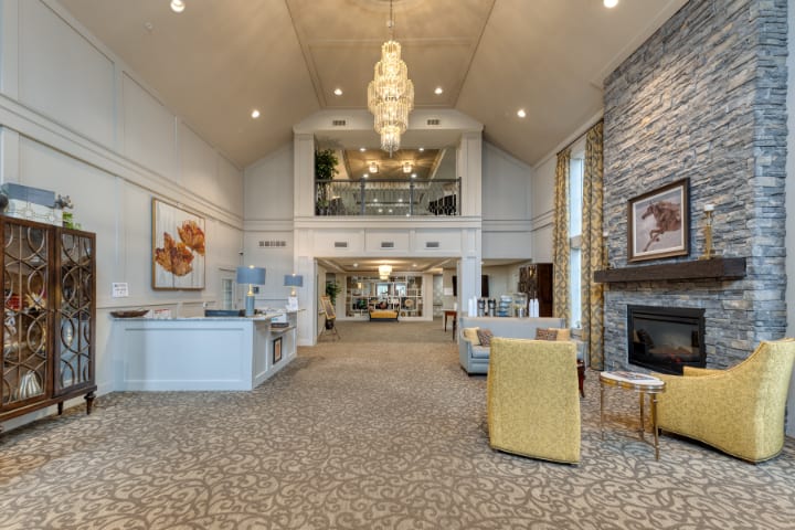 A spacious and modern lobby with a chandelier, fireplace, and seating area.