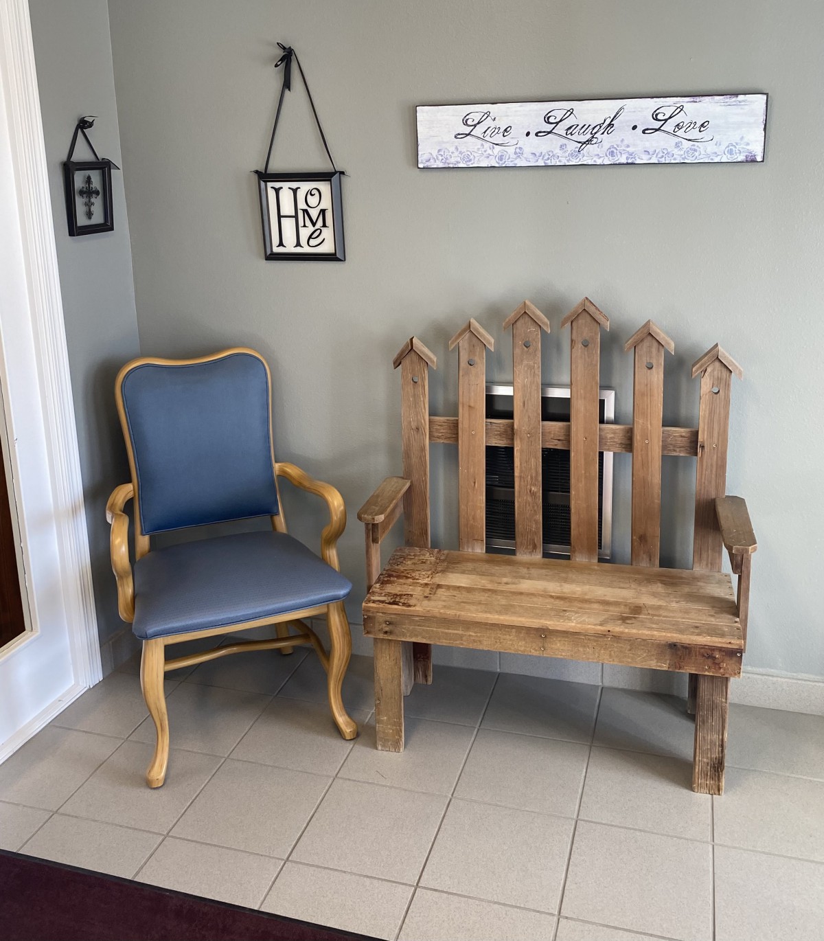 A cozy corner featuring a wooden bench and an upholstered chair, accented by decorative wall art.