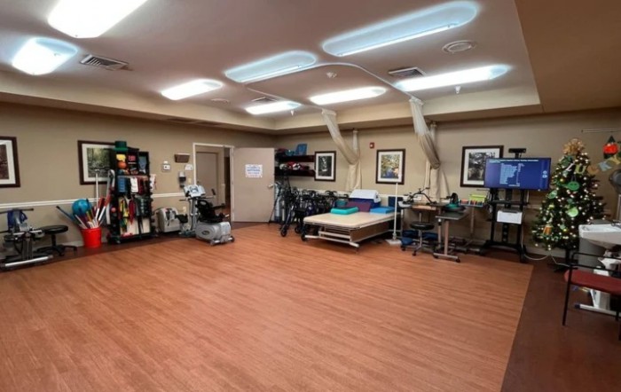 A spacious physical therapy room equipped with various exercise machines and tools for rehabilitation.