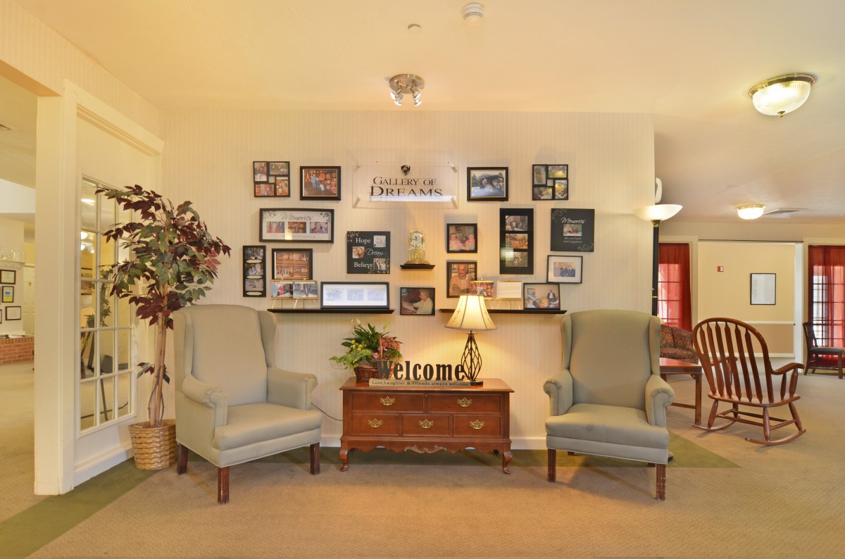 A cozy living room with two armchairs, a side table, and decorative wall art.