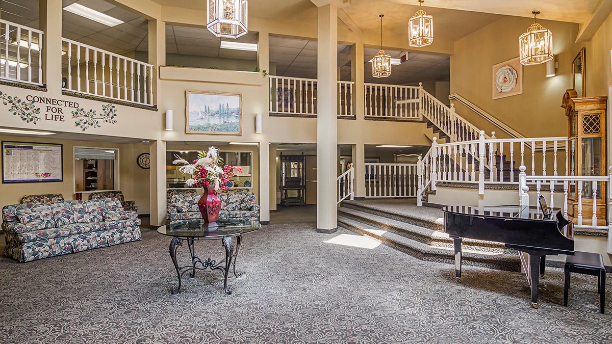 A spacious lobby featuring a grand staircase and elegant chandeliers.