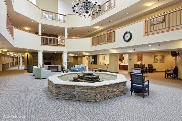 A spacious lobby area featuring a central fountain and elegant chandelier.